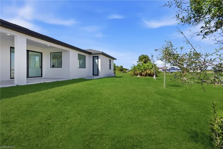 View of green lawn with a patio area