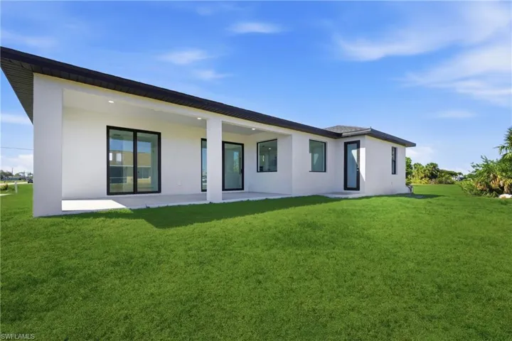 Back of property featuring a yard, a patio, and stucco siding