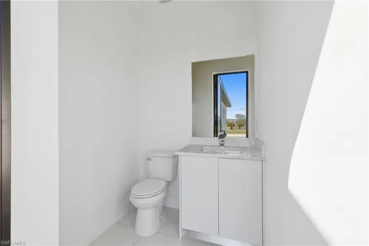 Half bathroom featuring vanity and toilet