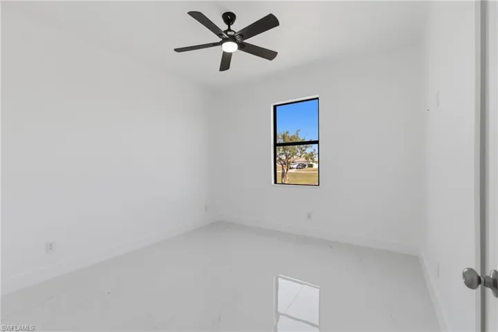 Empty room with light marble finish flooring and ceiling fan