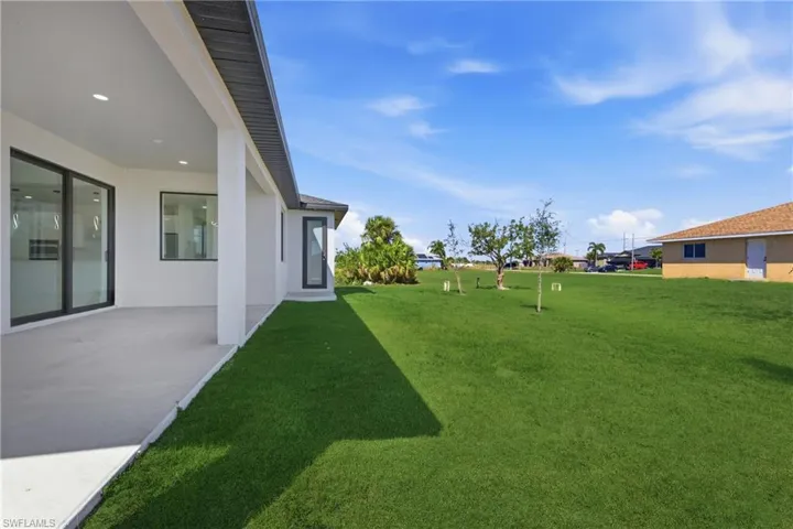 View of green lawn with a patio area