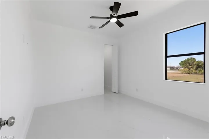 Spare room with ceiling fan and light marble finish floors
