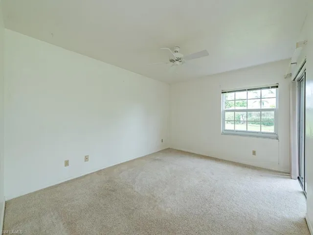 Carpeted empty room featuring ceiling fan