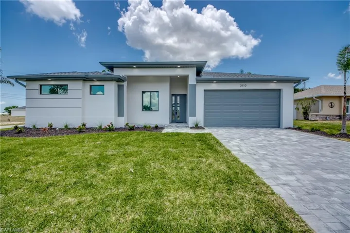 View of front of house featuring a garage and a front yard
