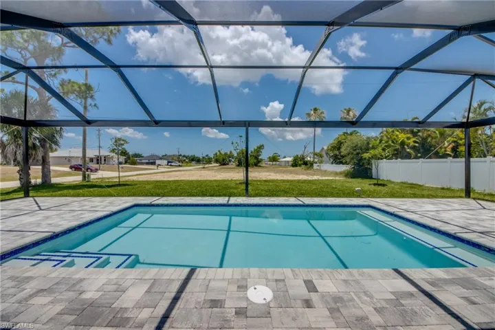 View of pool with a lanai and a yard