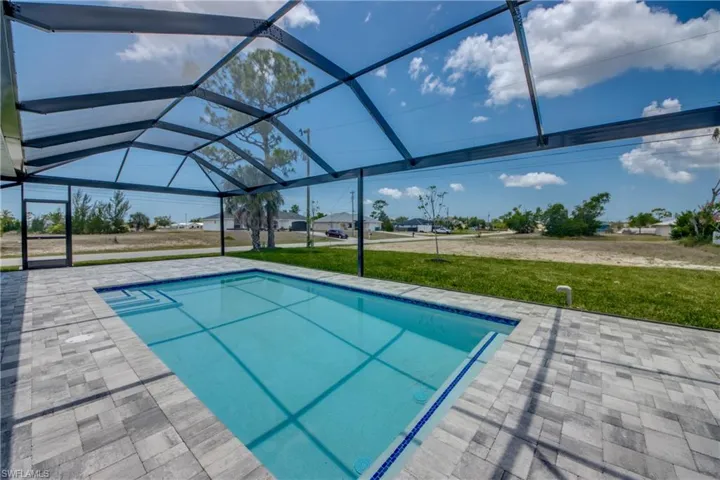 View of swimming pool featuring a lawn, a lanai, and a patio