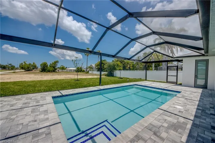 View of swimming pool featuring a lanai, a patio area, and a lawn