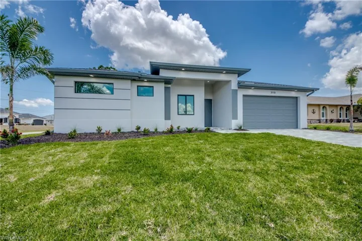 View of front facade with a garage and a front lawn