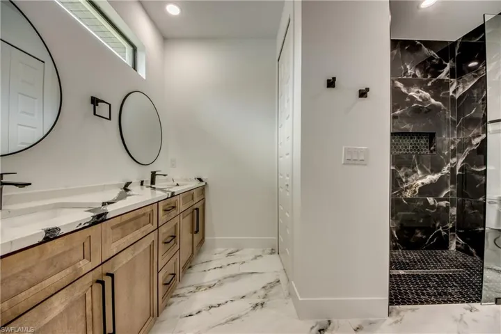 Bathroom with dual bowl vanity and tile floors