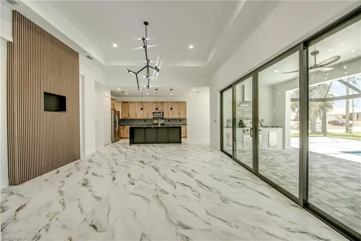Kitchen featuring a center island, appliances with stainless steel finishes, tasteful backsplash, ceiling fan, and light tile floors