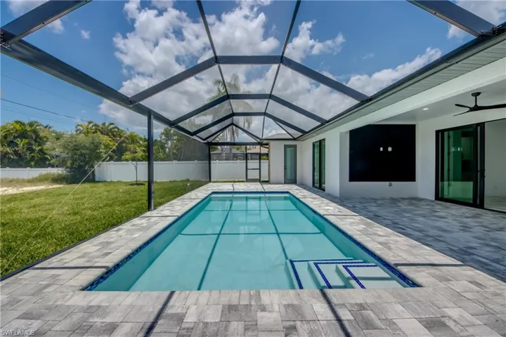 View of pool featuring a patio, a lanai, a lawn, and ceiling fan