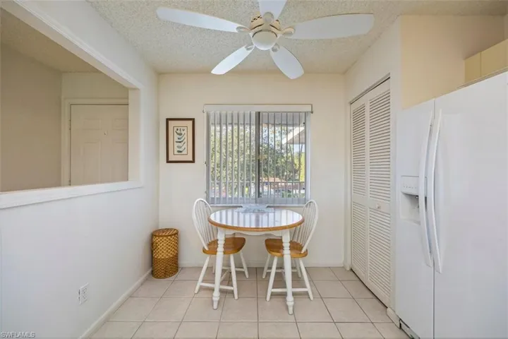 Dining space with light tile patterned floors, a ceiling fan, and a textured ceiling