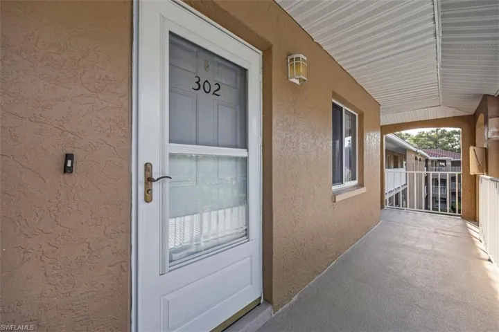 Entrance to property featuring stucco siding and a porch