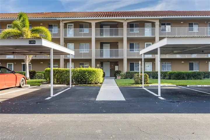 View of apartment building / complex with covered parking