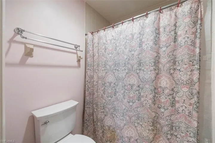 Bathroom featuring toilet and a shower with curtain