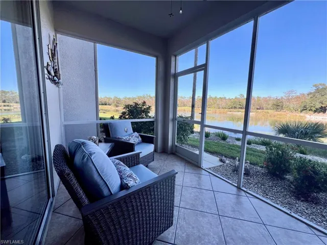 Sunroom / solarium with a water view and tile patterned flooring