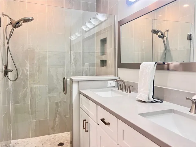 Bathroom with double vanity and a shower stall