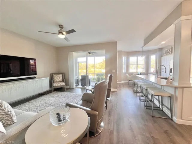 Living area with stressless recliners, 65" TV and ceiling fan.