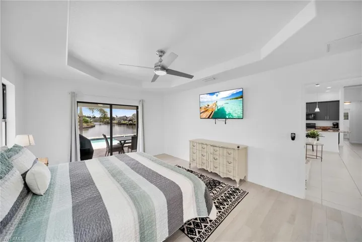Room featuring a tray ceiling with a ceiling fan