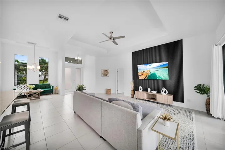 Spacious interior featuring white tile flooring, vaulted ceilings, and a striking black accent wall