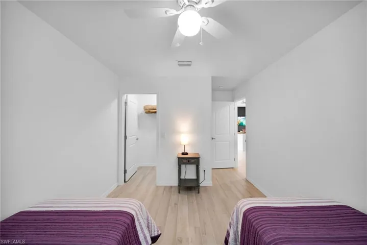 Light wood-finish flooring throughout, complemented by a ceiling fan with integrated lighting