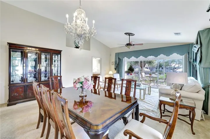 Formal dining room with vaulted ceiling, a ceiling fan, and a chandelier.  Tons of natural sun light.
