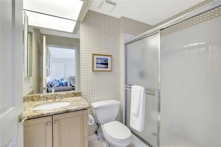 Ensuite 3rd bathroom featuring granite vanity countertops, and a shower.
