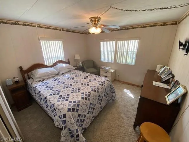 Carpeted bedroom featuring ceiling fan