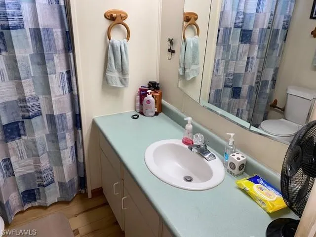 Bathroom featuring vanity, a shower with shower curtain, and light wood-type flooring
