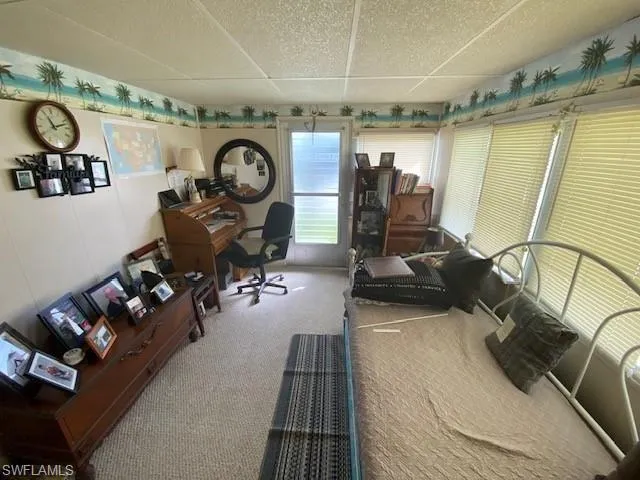 Carpeted office space featuring a paneled ceiling