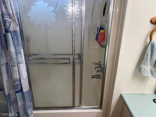 Bathroom featuring a shower stall and vanity