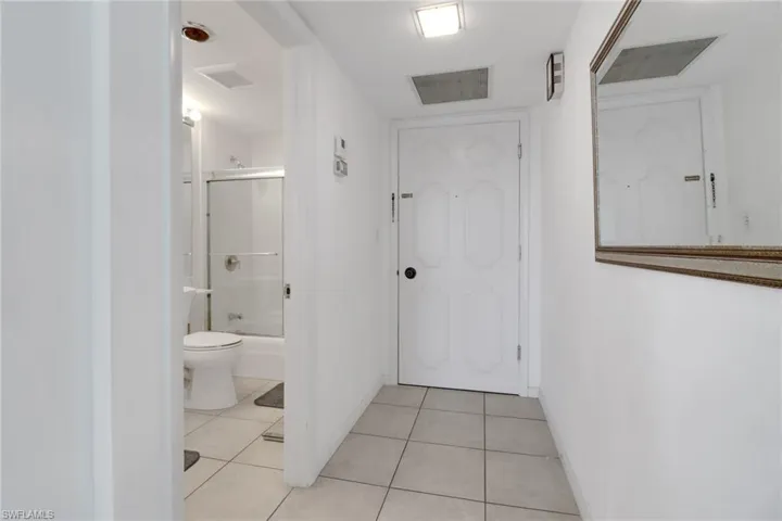 Hallway with light tile patterned floors and baseboards