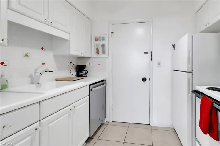 Kitchen with dishwasher, a sink, electric stove, white cabinets, and light tile patterned floors