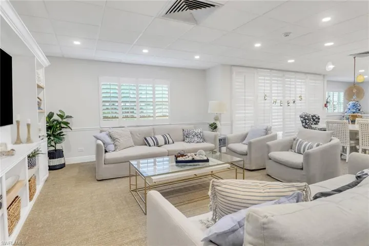 Living room featuring a paneled ceiling, light carpet, recessed lighting, and baseboards