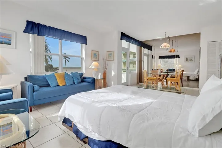 Bedroom with multiple windows, light tile patterned flooring, and a chandelier