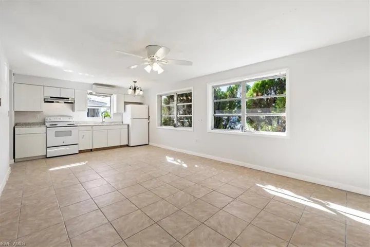 Kitchen featuring white appliances, white cabinetry, light countertops, and light tile patterned floors