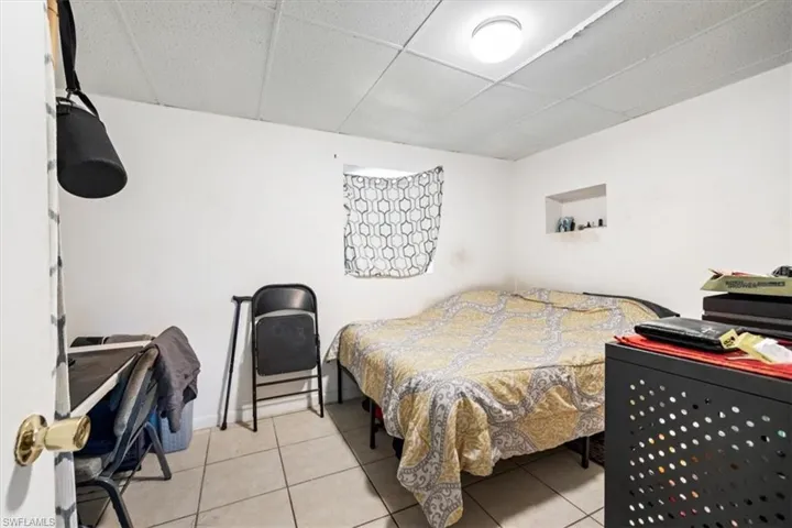 Bedroom featuring a drop ceiling and light tile patterned flooring