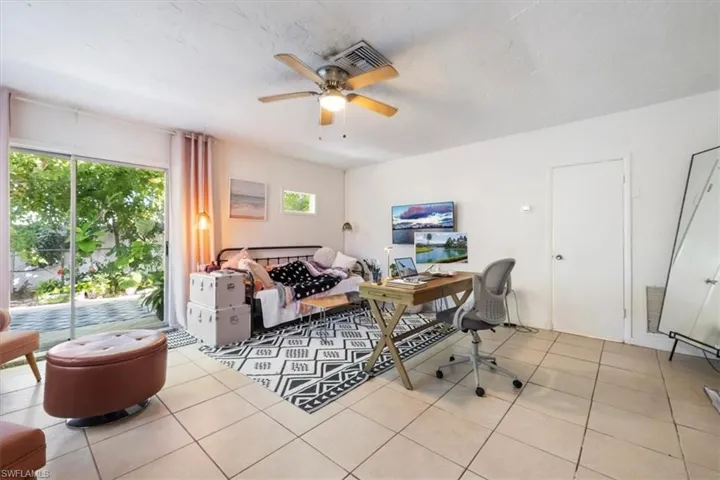 Home office featuring light tile patterned floors, ceiling fan, and a textured ceiling