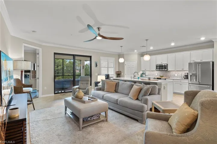 Tiled living room featuring ceiling fan, sink, and ornamental molding