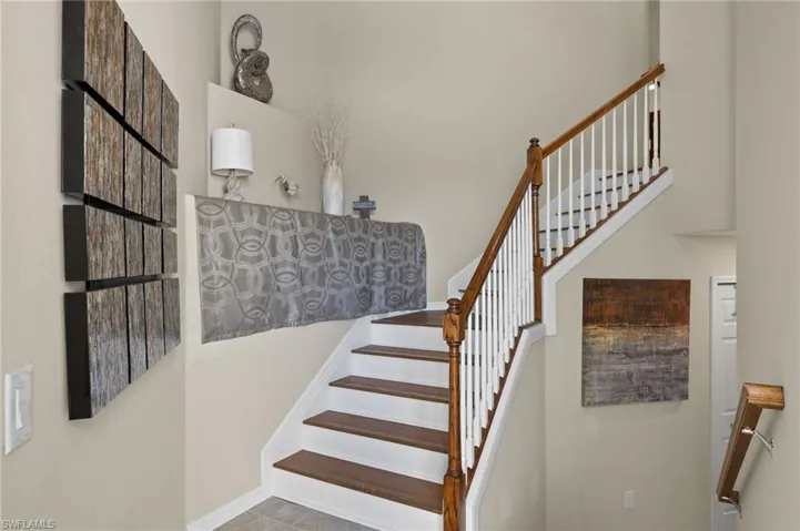Welcoming entry with wood floors on staircase