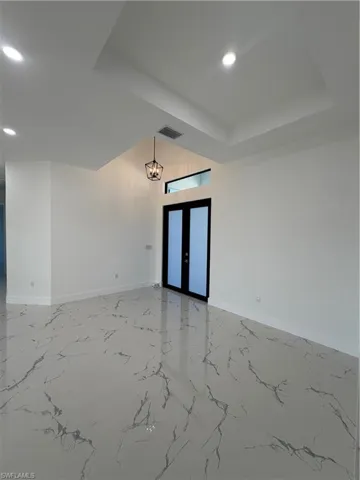 Unfurnished room featuring french doors, recessed lighting, and light marble finish flooring