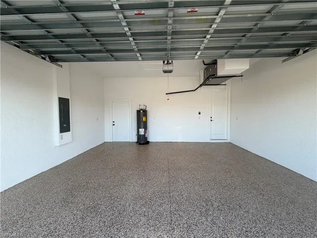 Garage featuring electric panel and water heater