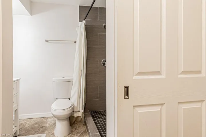 Bathroom featuring toilet, a shower with curtain, and vanity