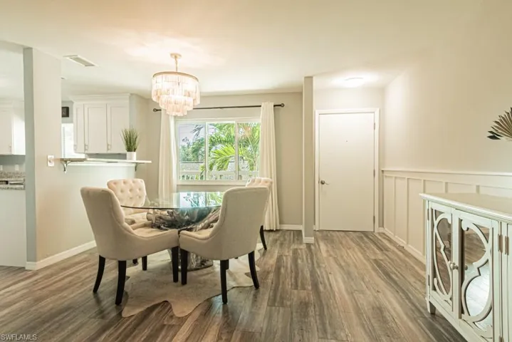 Dining area featuring a notable chandelier and dark wood-type flooring