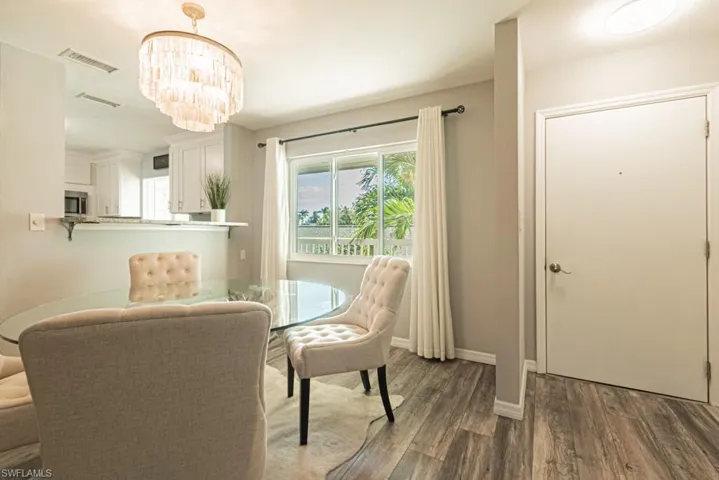 Dining room with a notable chandelier and dark hardwood / wood-style floors