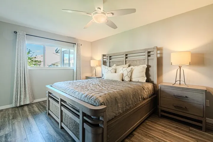 Primary bedroom with ceiling fan and dark hardwood / wood-style flooring