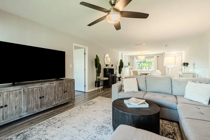 Living room with dark wood-type flooring and ceiling fan