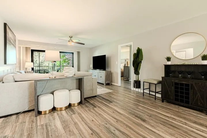 Living room with ceiling fan and hardwood / wood-style flooring