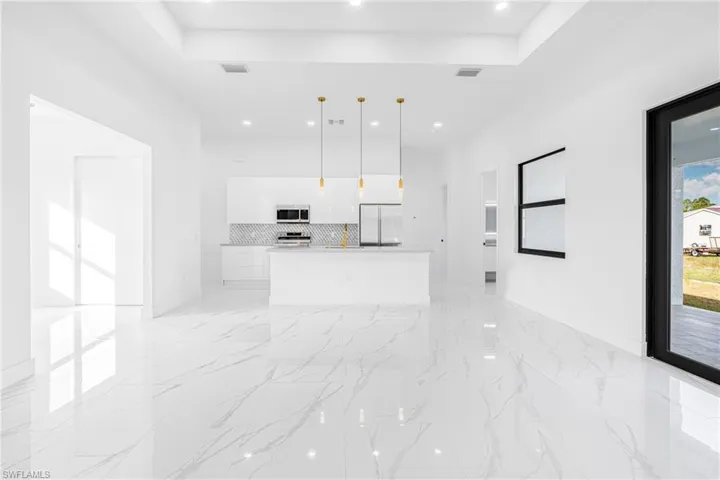 Unfurnished living room with a raised ceiling and recessed lighting