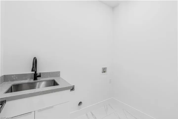 Laundry room with washer hookup, light marble finish floors, and hookup for an electric dryer